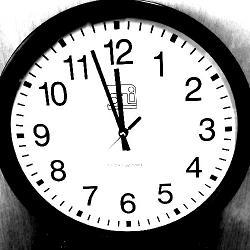 A clock showing the time as three minutes before 12.