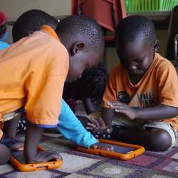 Students in Uganda using a tablet computer.