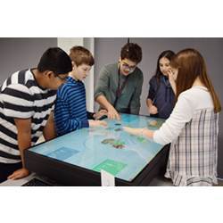 Students from University Laboratory High School use the Food for Thought app on a 55-inch touch-screen computer.