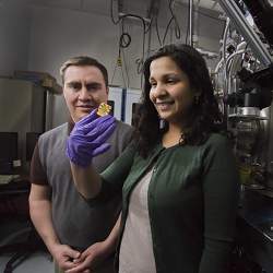 Researchers Jose Pacheco and Meenakshi Singh, who holds an sample qubit structure embedded in silicon.