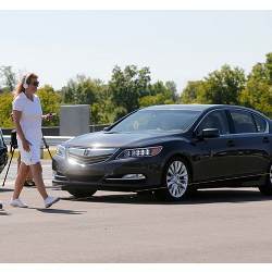 A pedestrian crosses in front of a vehicle at Mcity, a test site for driverless vehicles on the University of Michigan campus in Ann Arbor.