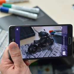 An Augmented Reality app makes it appear as if a motorcycle were parked on top of the desk.