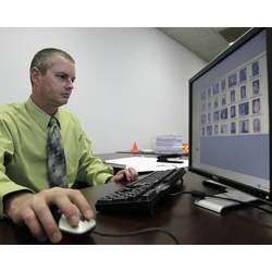 A researchers in the ID fraud unit of the North Carolina Department of Motor Vehicles examines photos in a facial recognition system.