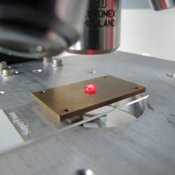 An artificial diamond under the optical microscope; nitrogen defects make the diamond fluoresce.