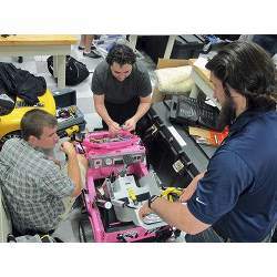 University of North Florida students work to customize a toy car so it can be used by a girl with cerebral palsy.