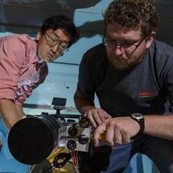 Jeongwan Jin and Chris Pugh of the University of Waterloo's Institute for Quantum Computing install a telescope in a National Research Council aircraft. 