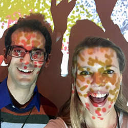 A visualization of protein families is projected onto researchers Mehrdad Yazdani (left) and Bryn Taylor in the University of California San Diego Center for Microbiome Innovation.