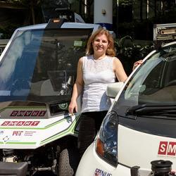 Massachusetts Institute of Technology professor Daniela Rus stands with autonomous SMART vehicles.