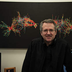 Texas A&M University professor Tim Davis in front of a music visualization.