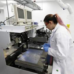 Ph.D. student Caitlin Cramer uses a machine that can print electrical circuits and solar cells at a lab at the University of Washington.