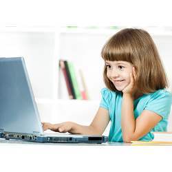 A young girl uses a laptop. 