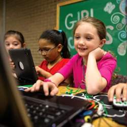 A Girl Scout works on a laptop computer.