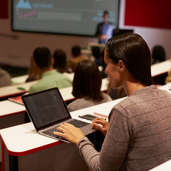 student with laptop in classroom