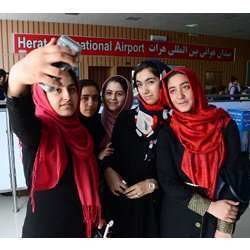 Afghan teens from the Afghanistan Robotic House take photos at Herat International Airport before embarking for the U.S. 