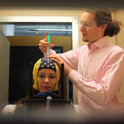 A researcher applies contact gel, to achieve better brain signal transmission quality.