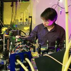 Milos Rancic with the experimental setup used to investigate materials for a telecom-compatible quantum memory.