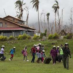 A U.S. Naval Aircrewman leads residents of Puerto Rico to a helicopter for evacuation following the landfall of Hurricane Maria.