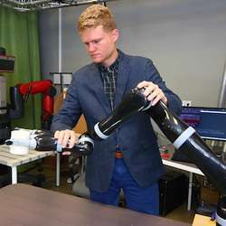 Rice University graduate student Dylan Losey using gentle feedback to train a robot arm to manipulate a coffee cup in real time. 