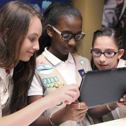 Girl Scouts viewing tablet computer