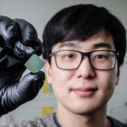 University of Illinois student Benjamin Sohn holds a device that uses sound waves to produce optical diodes.