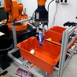 A pick-and-place robot sorts items into different bins.