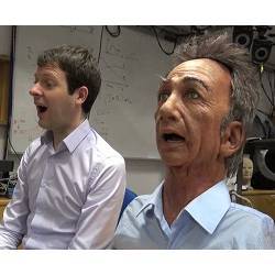 The Charles robot (right) mimics the facial expression of a human subject.