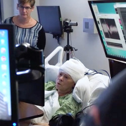 patient with electrodes in brain uses a touchscreen