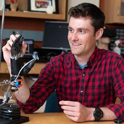 Johns Hopkins University graduate student Luke Osborn interacts with a prosthetic hand sporting e-dermis.