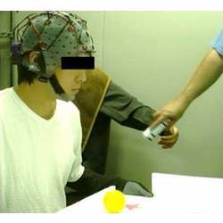 A study volunteer balancing a ball on a board held by his own hands while the robot arm grabs a bottle.