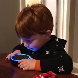 A young boy speaks to the Amazon Echo Dot.