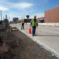 Examining the road bed prior to installing sensor-laden concrete.