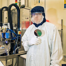 Process Engineer Richard Kasica holds a silicon wafer in an NIST cleanroom.