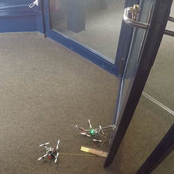 Drones cooperate to open a door.