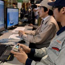 Toshiba workers test a remotely operated underwater vehicle.