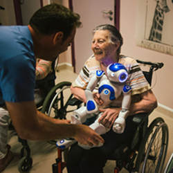 A nursing facility resident enjoying the Zora robot.