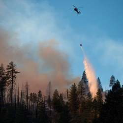 A helicopter drops water on a California wildfire.