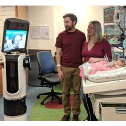 Children's National cardiologist Alejandro Lopez-Magallon remotely checks in on a patient and speaks to her parents using Dr. Bear Bot.