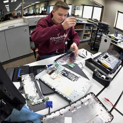Bismarck High School student Jacob Livingston, one of five student interns in the school's Tech Daemons Help Desk program, salvages parts from a used laptop.