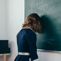 girl with head against blackboard