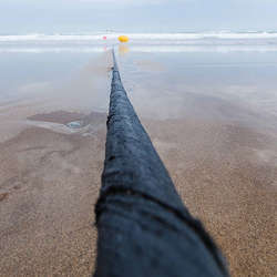 A submarine fiber-optic cable at the shoreline.