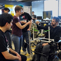 Team Alex works with Alex Rosenberg seated in wheelchair