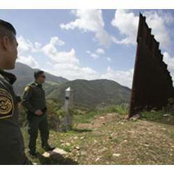 Border Patrol agents view the end of a border fence in the Otay Mountain Wilderness in southern California. 