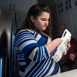 Josie Fraticelli examines a powered prosthetic made for her.