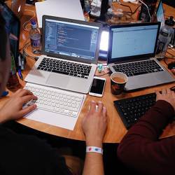 Attendees working on Apple Inc. laptop computers participate in the TechCrunch Disrupt London 2015 Hackathon.