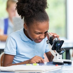 female student peering into a microscope