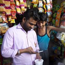 A customer on his smartphone outside a shop in New Delhi, India.