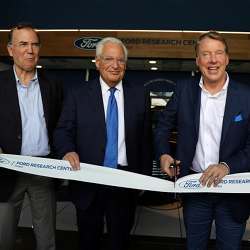 Ford Motor chairman Bill Ford (center) stands next to U.S. Ambassador to Israel David Friedman as he cuts the ribbon marking the opening of Ford's research center in Tel Aviv.