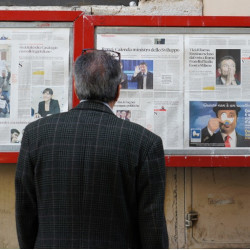 man reading newspaper pages