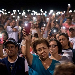 people holding up phones at prayer service in El Paso