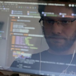 programmer's face reflected in computer screen